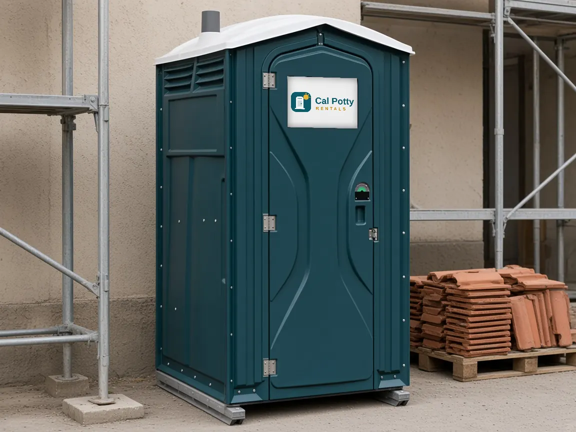 A teal porta potty beside scaffolding and a pallet of roof tiles